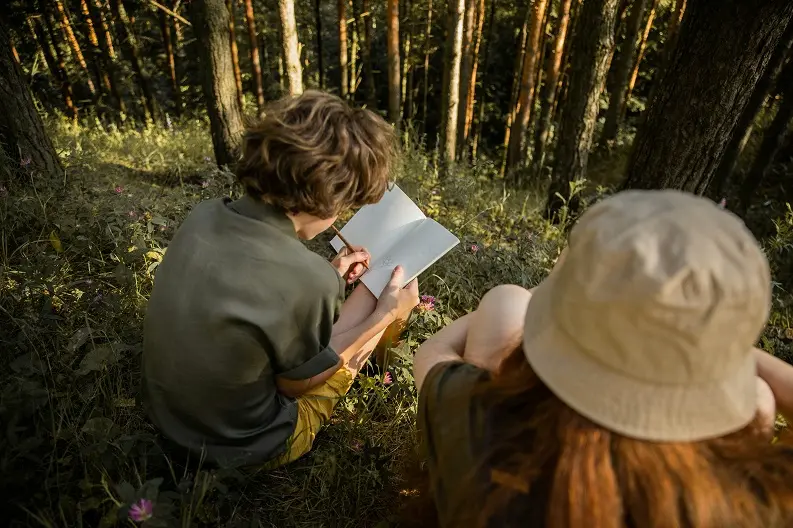 Deux jeunes qui dessinent dans la nature